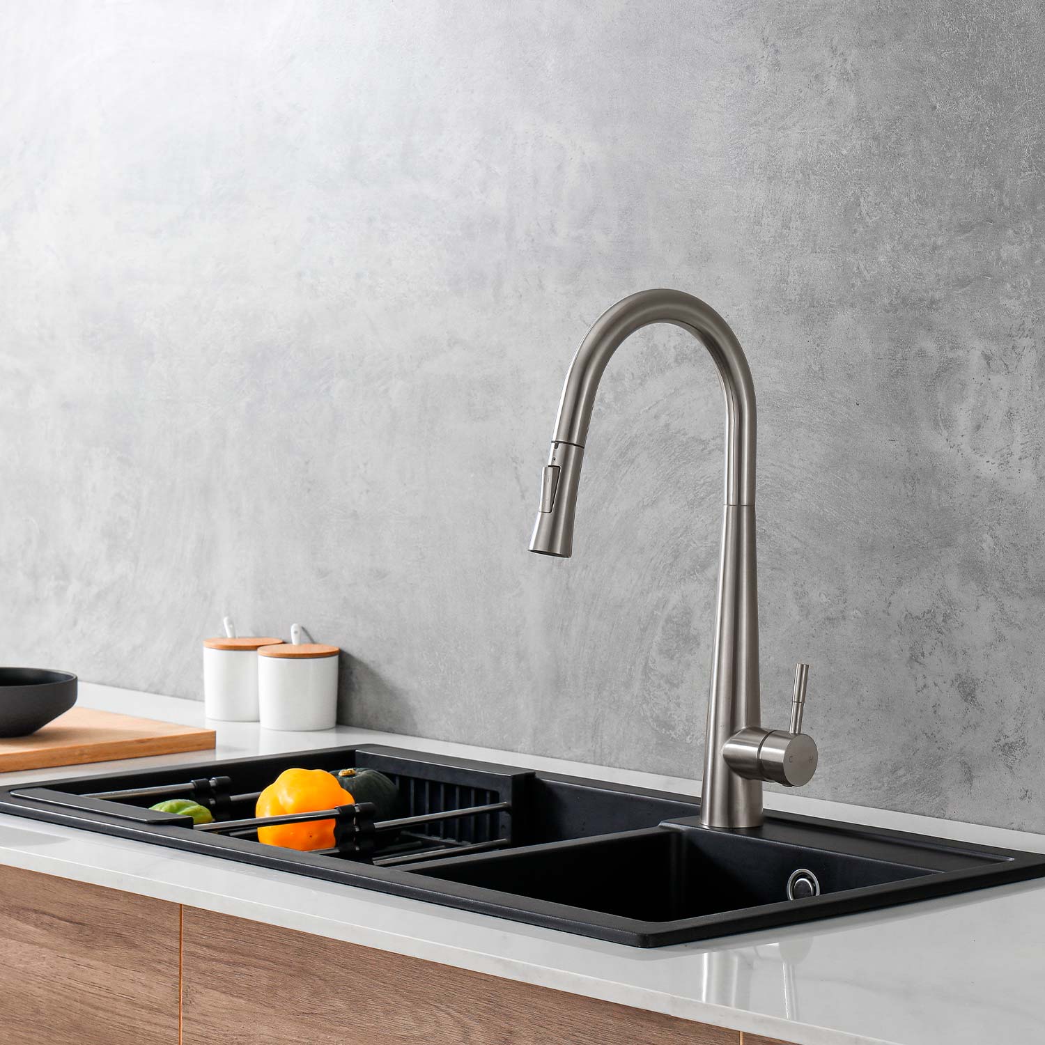 Modern kitchen sink with a faucet against a gray wall.