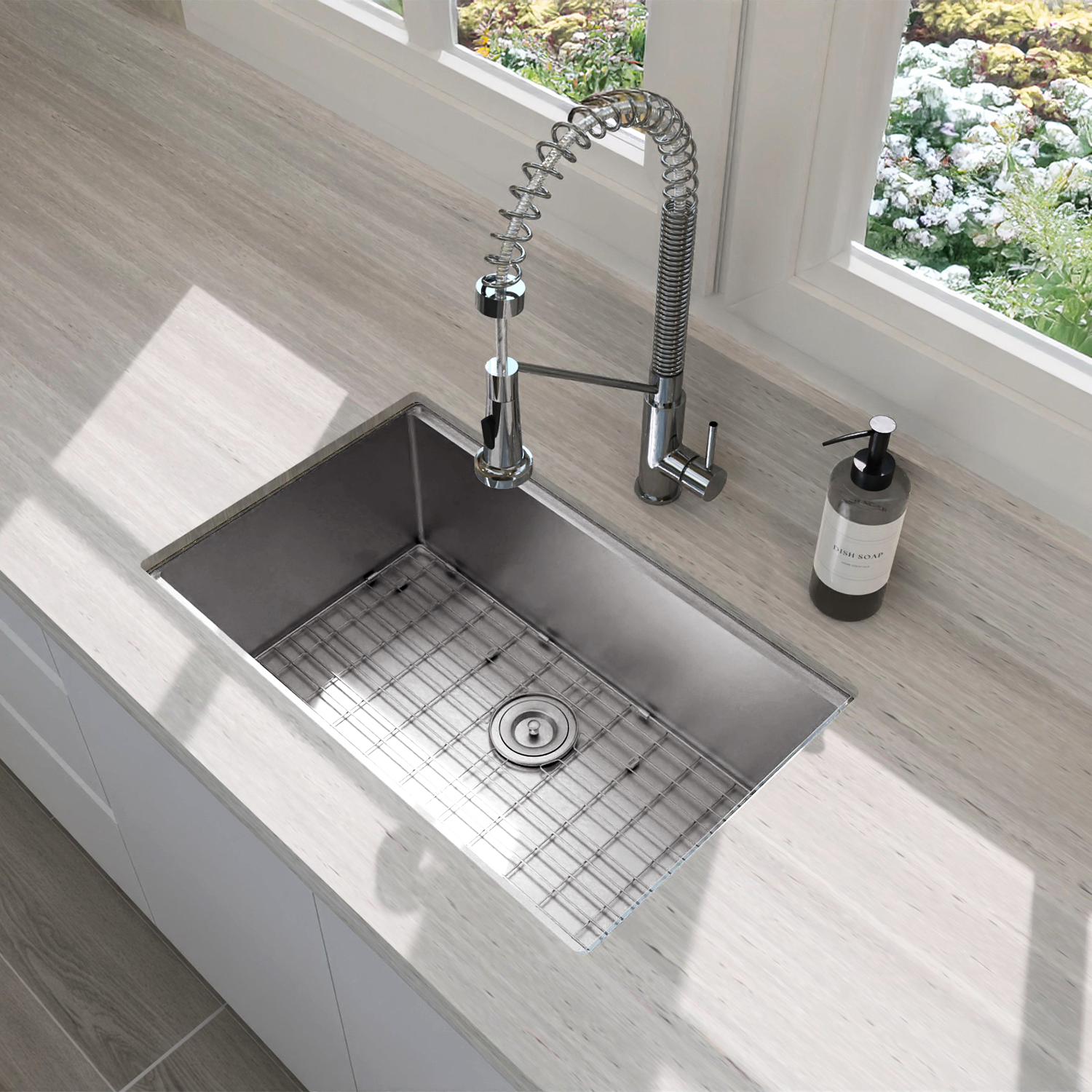 Stainless steel kitchen sink with faucet and soap dispenser on a light-colored countertop.