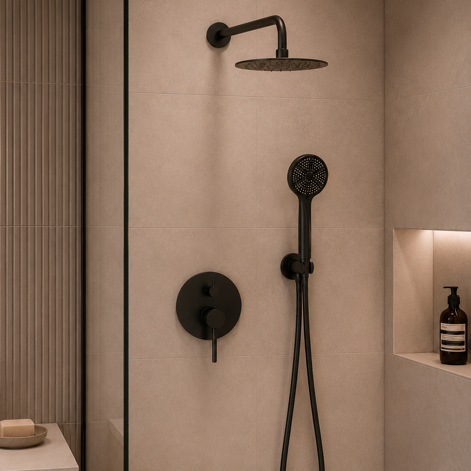 A matte black shower fixture set including a round rain head, handheld shower with hose, and wall-mounted control valve, installed on beige tiled walls in a modern bathroom.